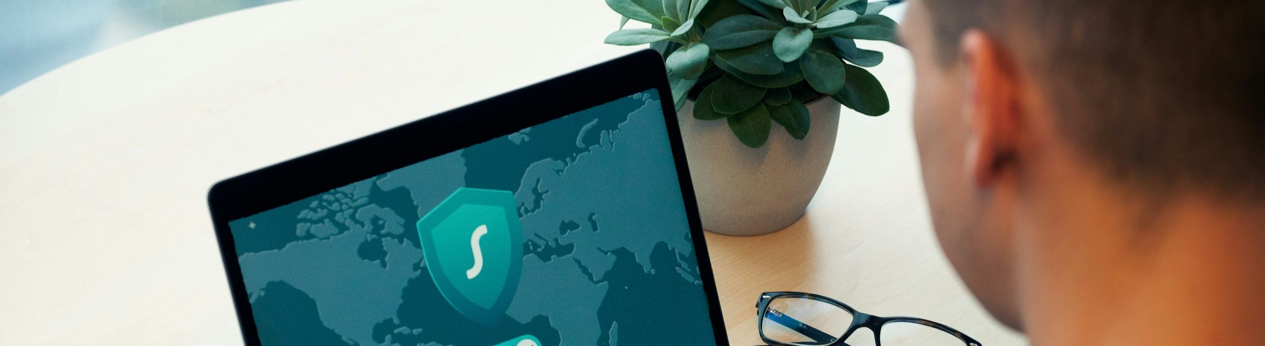 Laptop with a world map and security shield icon