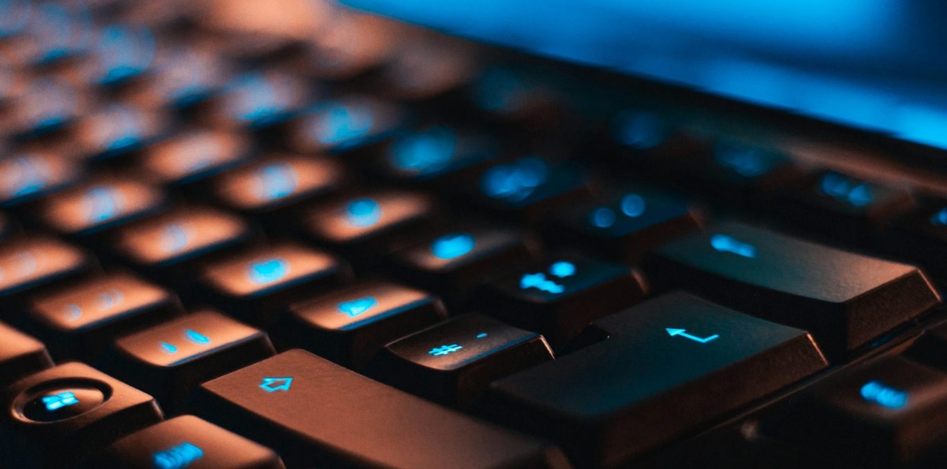 Close-up of a computer keyboard with blue security lighting
